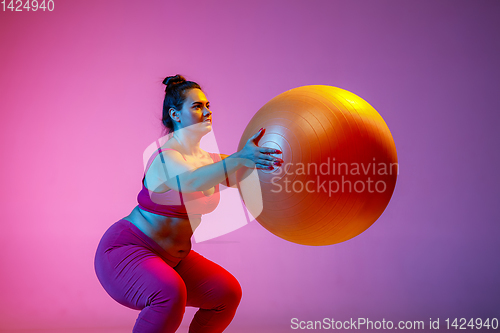 Image of Young caucasian plus size female model\'s training on gradient background