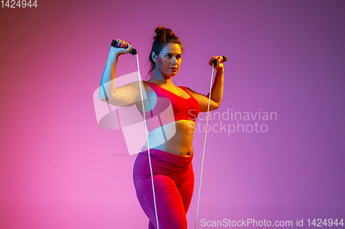 Image of Young caucasian plus size female model\'s training on gradient background