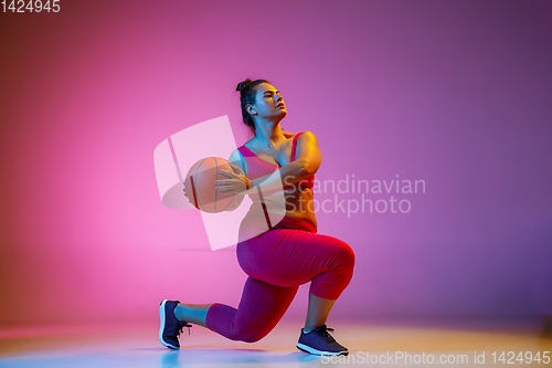 Image of Young caucasian plus size female model\'s training on gradient background