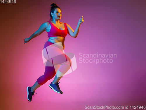 Image of Young caucasian plus size female model\'s training on gradient background