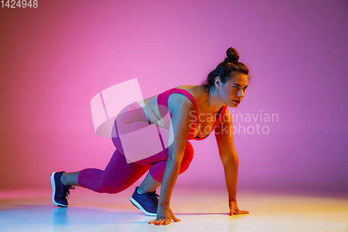 Image of Young caucasian plus size female model\'s training on gradient background