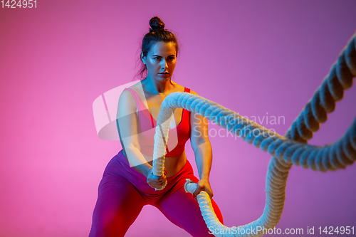 Image of Young caucasian plus size female model\'s training on gradient background