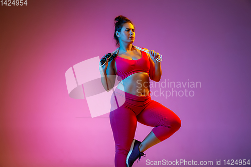 Image of Young caucasian plus size female model\'s training on gradient background