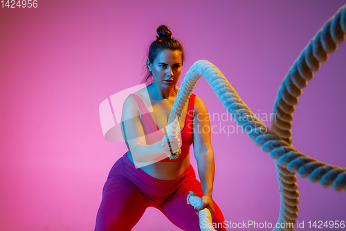 Image of Young caucasian plus size female model\'s training on gradient background