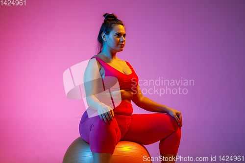 Image of Young caucasian plus size female model\'s training on gradient background