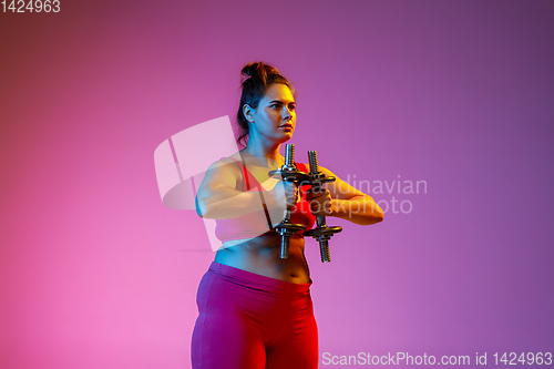 Image of Young caucasian plus size female model\'s training on gradient background