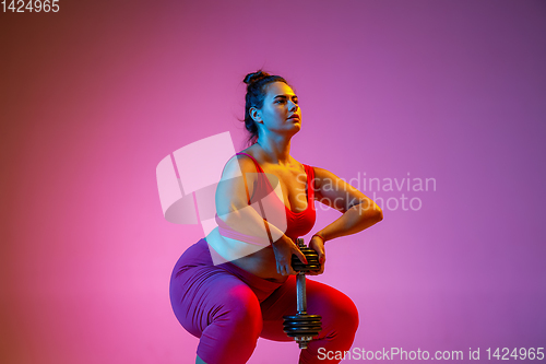 Image of Young caucasian plus size female model\'s training on gradient background