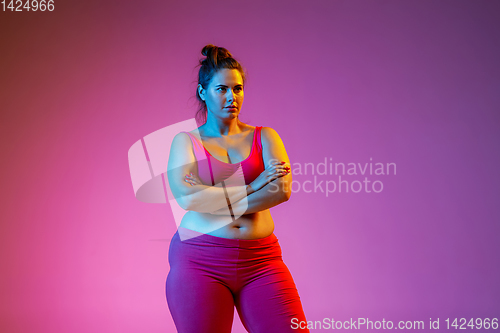 Image of Young caucasian plus size female model\'s training on gradient background