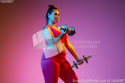 Image of Young caucasian plus size female model\'s training on gradient background