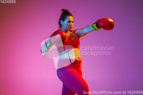 Image of Young caucasian plus size female model\'s training on gradient background