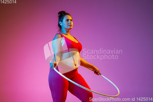 Image of Young caucasian plus size female model\'s training on gradient background