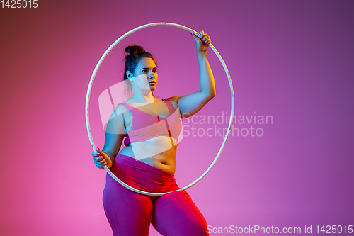 Image of Young caucasian plus size female model\'s training on gradient background
