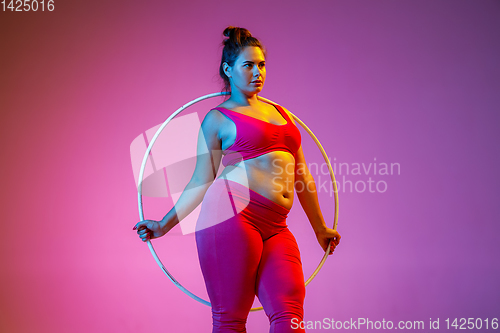 Image of Young caucasian plus size female model\'s training on gradient background