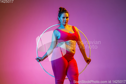 Image of Young caucasian plus size female model\'s training on gradient background