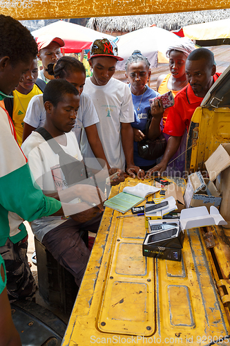 Image of Man sell cellular phones on rural Madagascar marketplace