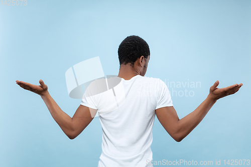 Image of Half-length close up portrait of young man on blue background.