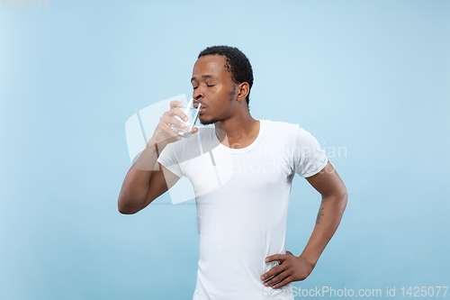 Image of Half-length close up portrait of young man on blue background.