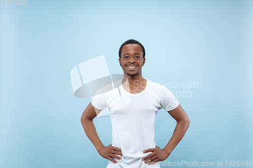 Image of Half-length close up portrait of young man on blue background.