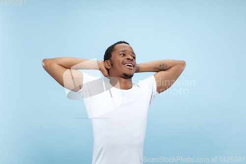 Image of Half-length close up portrait of young man on blue background.