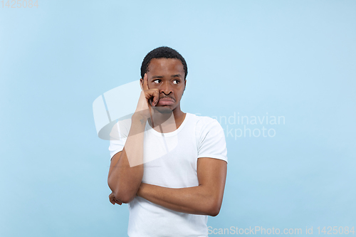 Image of Half-length close up portrait of young man on blue background.