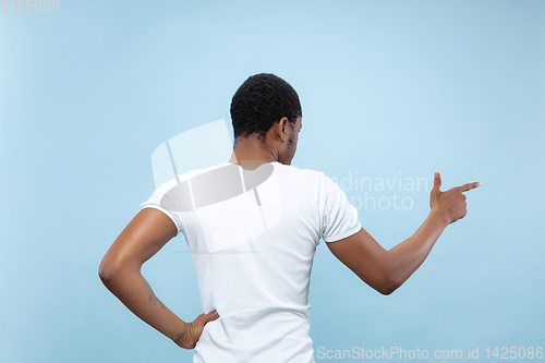 Image of Half-length close up portrait of young man on blue background.