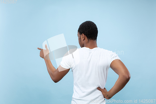 Image of Half-length close up portrait of young man on blue background.