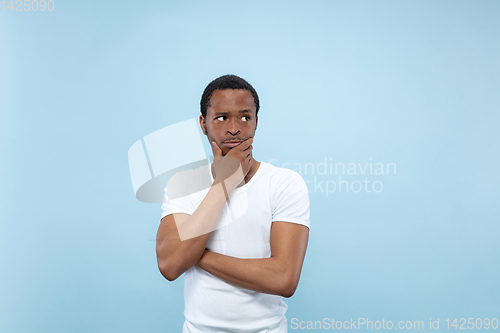 Image of Half-length close up portrait of young man on blue background.