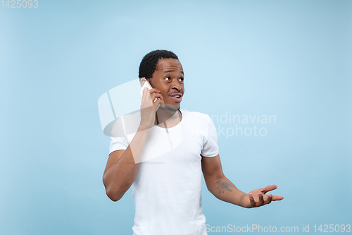 Image of Half-length close up portrait of young man on blue background.
