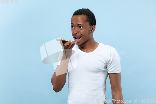 Image of Half-length close up portrait of young man on blue background.
