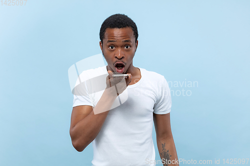 Image of Half-length close up portrait of young man on blue background.