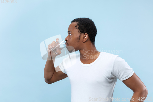 Image of Half-length close up portrait of young man on blue background.