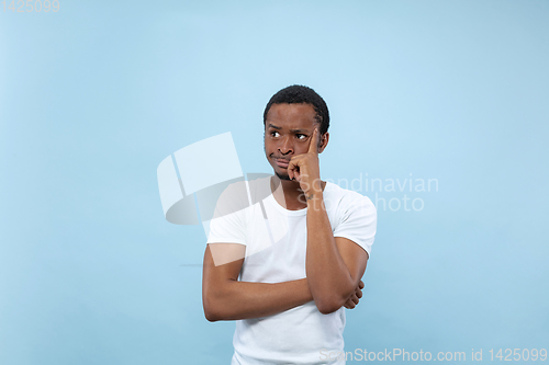 Image of Half-length close up portrait of young man on blue background.