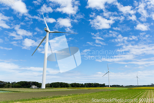 Image of Wind turbine and field with blue sky