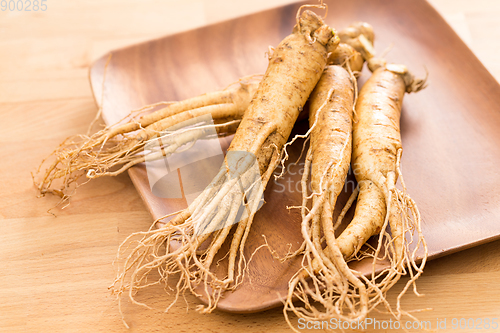 Image of Fresh ginseng root over wooden background