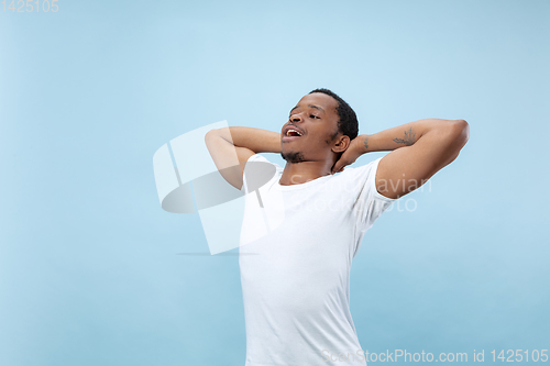 Image of Half-length close up portrait of young man on blue background.