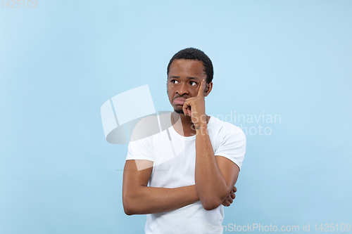 Image of Half-length close up portrait of young man on blue background.