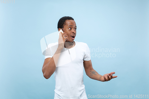 Image of Half-length close up portrait of young man on blue background.