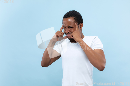 Image of Half-length close up portrait of young man on blue background.