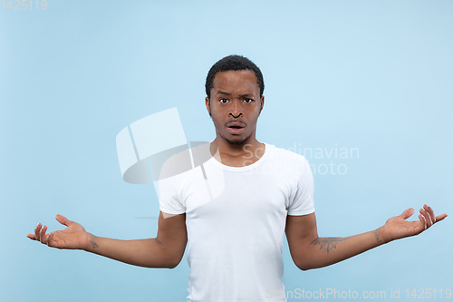 Image of Half-length close up portrait of young man on blue background.