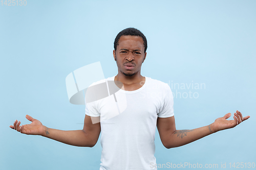 Image of Half-length close up portrait of young man on blue background.