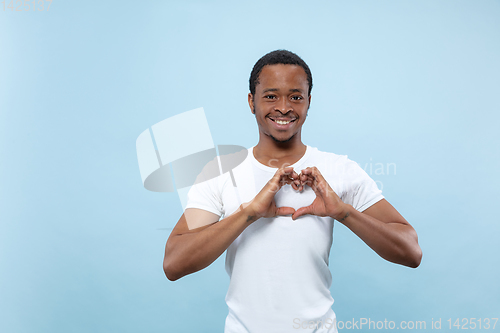 Image of Half-length close up portrait of young man on blue background.