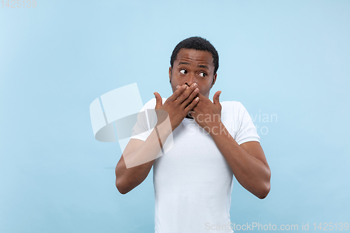 Image of Half-length close up portrait of young man on blue background.