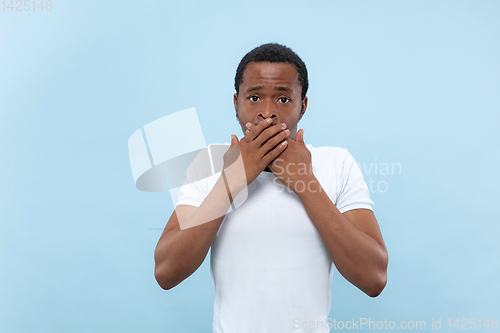 Image of Half-length close up portrait of young man on blue background.