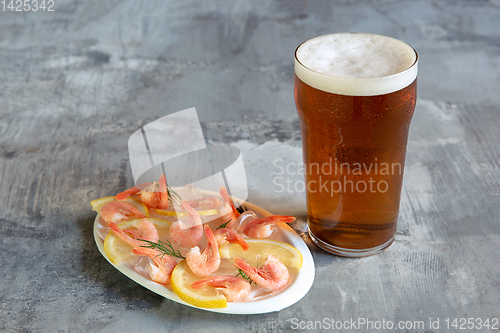 Image of Glass of light beer on white stone background