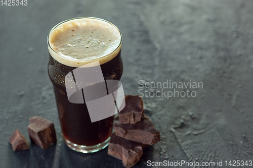 Image of Glass of dark beer on the stone table background