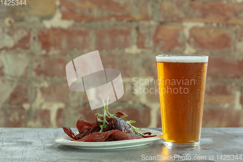 Image of Glass of light beer on the stone table and brick\'s background