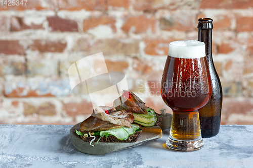 Image of Glass of beer on the stone table and brick\'s background