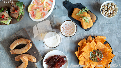 Image of Top view of beer glasses with foam on top and delicious snacks