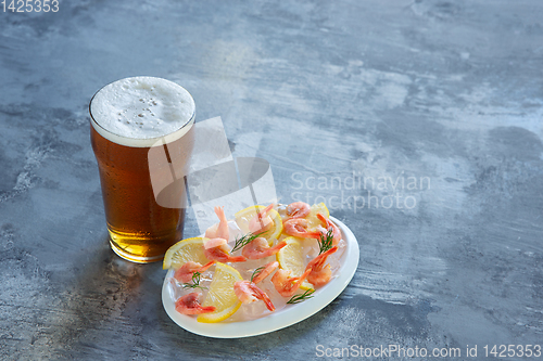 Image of Glass of light beer on white stone background