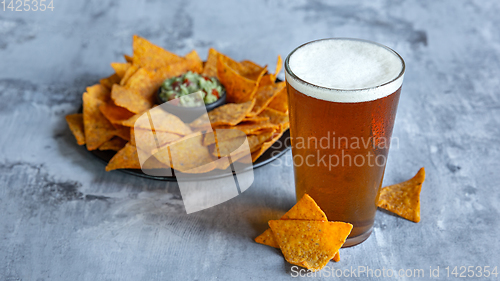 Image of Glass of light beer on white stone background